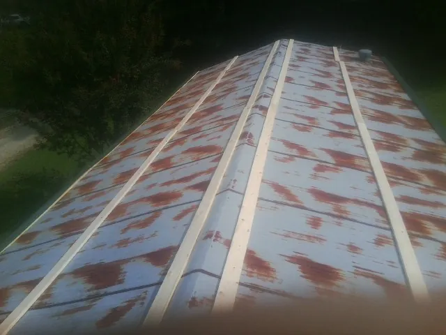 Rusted metal roof panels with new wood purlins before replacement — Storm Damage Roof Repair in Travis Afb by Roofing Brothers