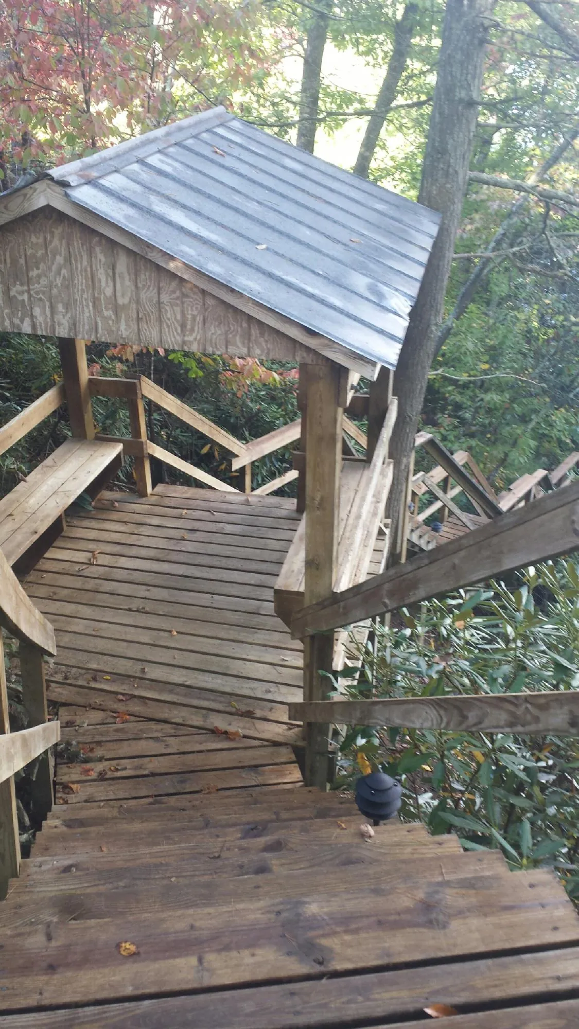 Metal roofed shelter over wooden steps on a wooded walkway — Skylight Repair & Installation work by our crew in Travis Afb