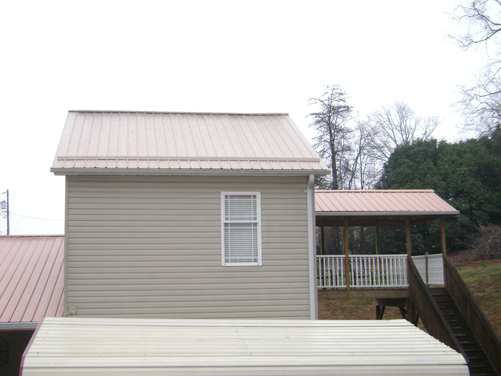 Tan metal roofs on a two story addition and attached porch in Travis Afb
